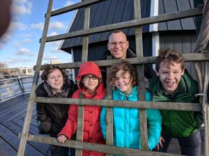 Family of 5 poses in the wings of a windmill