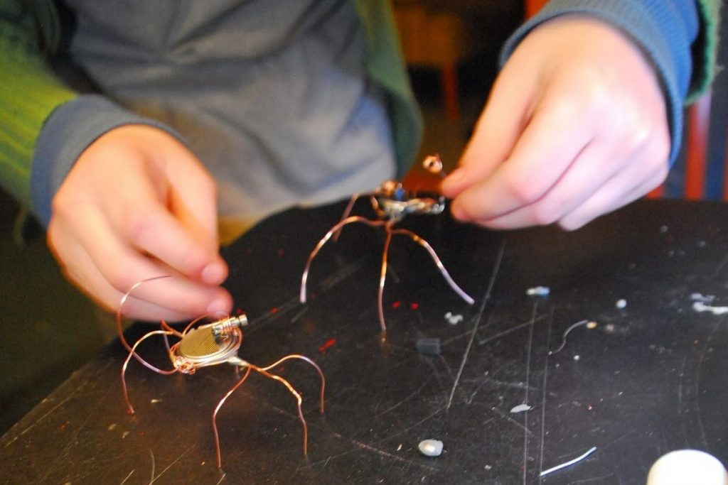 child with copper wire bent to look like a spider