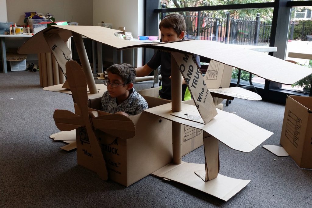 kids in a cardboard triplane