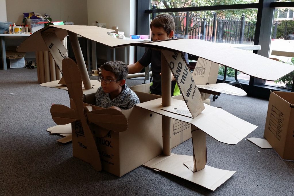 kids in a cardboard triplane