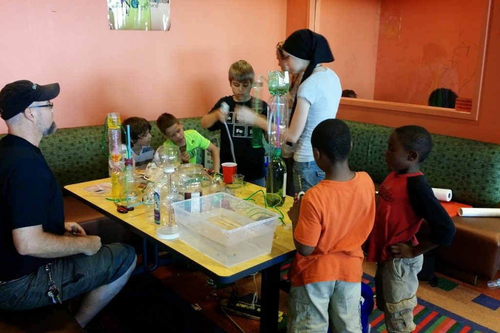 kids making heron fountains out of 2 liter bottles