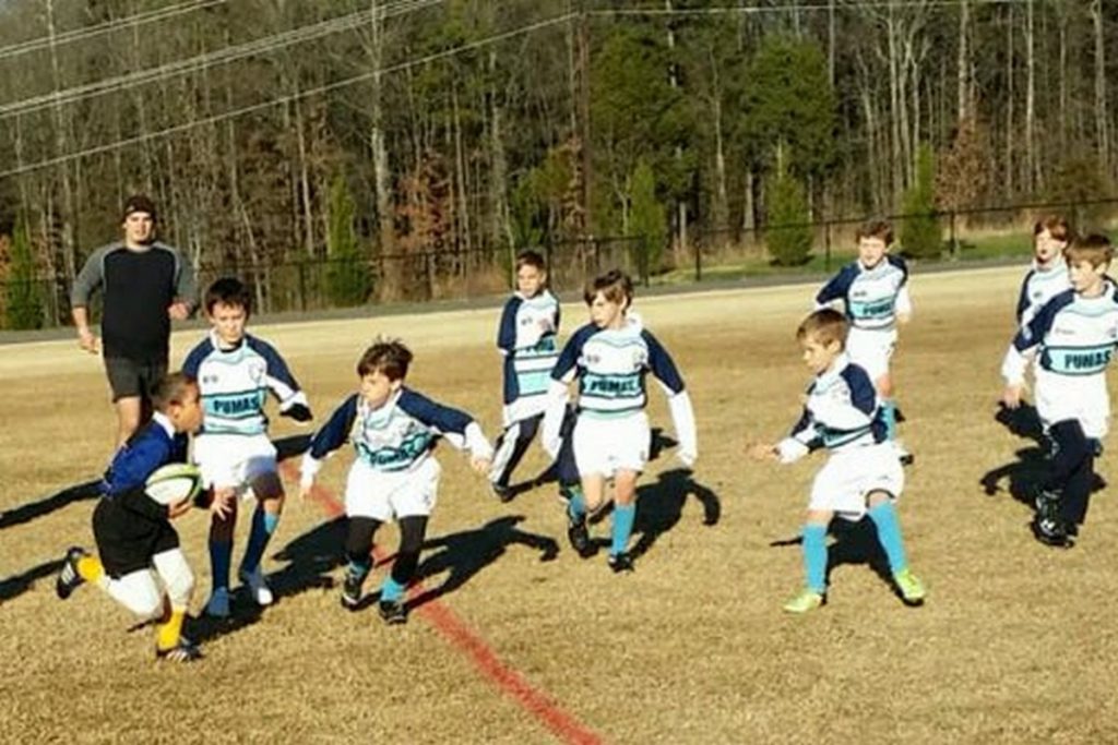 One elementary school rugby player against and entire team.