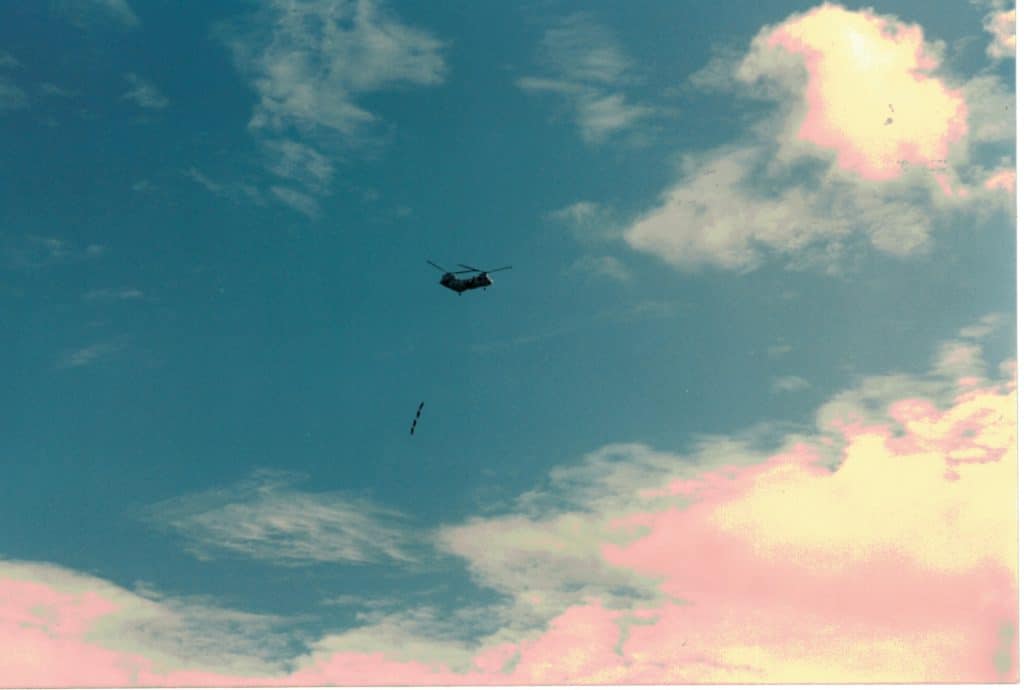 helicopter dangling people one hundred feet below on a rope