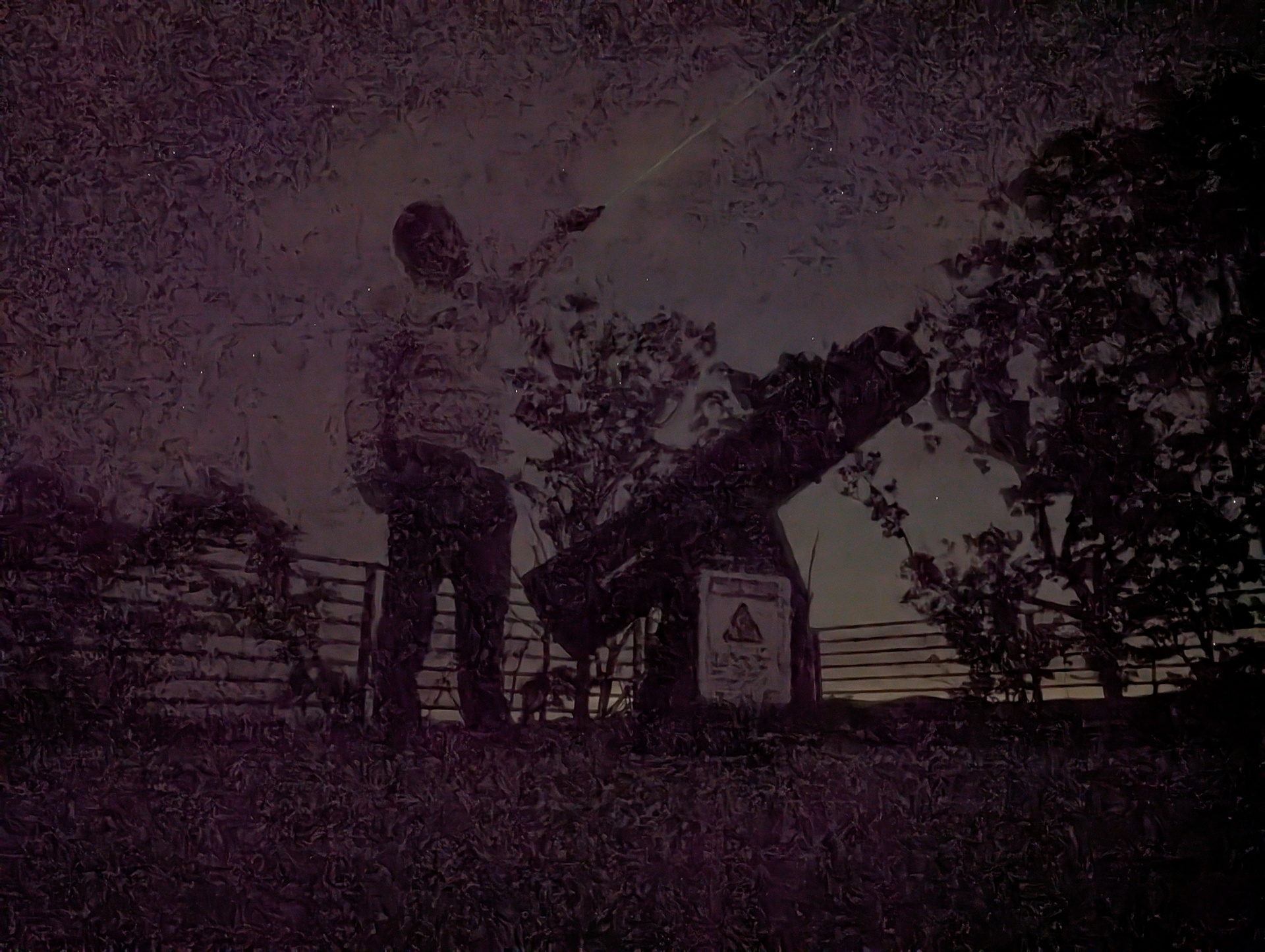 Very dark photo of person looking into the night sky next to a large telescope