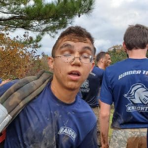 tired looking teenager covered in mud