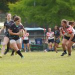 girl running in a match with rugby ball