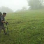 boy carrying a backpack nearly as large as him