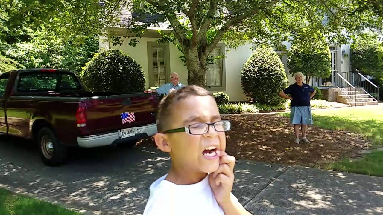 Boy holding mouth open as his tooth is removed by a rocket