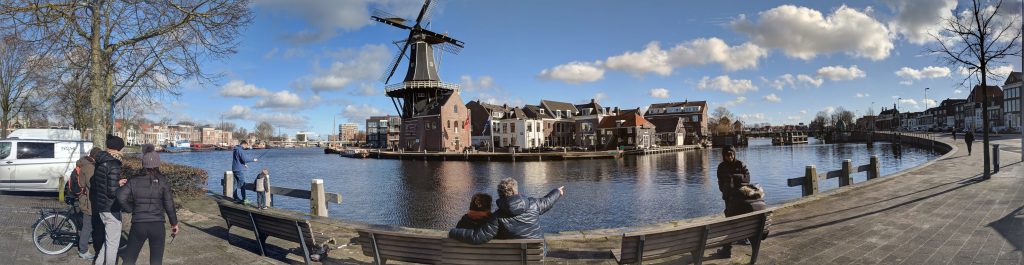 Panoramic view of a river that wraps around a windmill